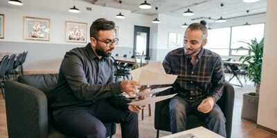 To menn sitter og går over kontrakter. Foto