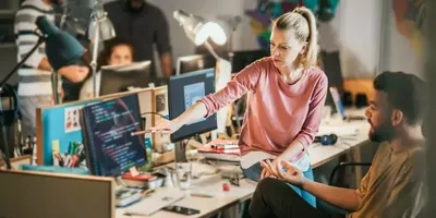 En dame viser frem koder på en skjerm. Foto